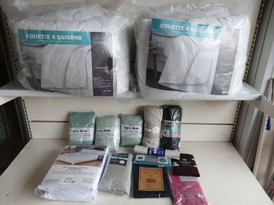 a shelf with a lot of bedding and pillows on it