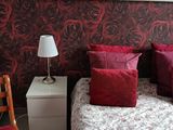 un lit avec des oreillers rouges et un miroir au-dessus