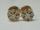 une paire de boucles d'oreilles à clous en diamant posées sur une surface blanche