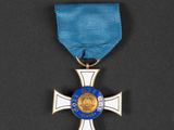 a silver cross with a blue ribbon on a black background