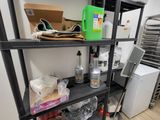 une étagère noire sur laquelle sont posés de nombreux objets, dans une pièce