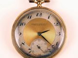 a close up of a pocket watch on a white surface