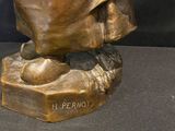 bronze statue of a man with a hat and cloak on a base