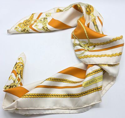 une écharpe orange et blanche ornée d'une chaîne dorée