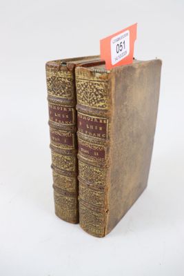 deux vieux livres posés l'un sur l'autre sur une table