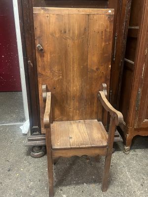 une chaise en bois posée devant une armoire en bois