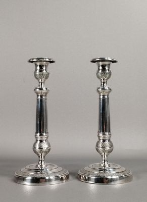 pair of silver candlesticks on a silver background