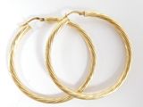 deux paires de boucles d'oreilles créoles en or sur fond blanc