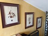three framed pictures on the wall above a bed