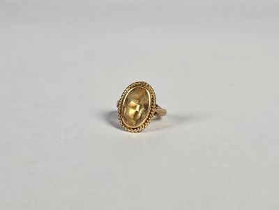 une bague en or avec une pierre jaune au centre