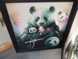 framed picture of a panda bear holding a knife with two other panda bears in the background