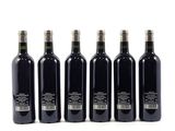 six bottles of wine are lined up in a row on a white surface