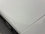 a close up of a white car with scratches on it ' s hood