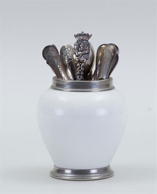 a white vase with spoons and spoons in it