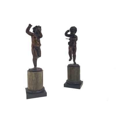 une paire de figurines en bronze représentant un garçon et une fille, posées sur des socles