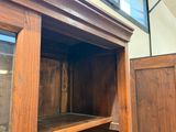 un meuble en bois avec une porte en verre dans une pièce