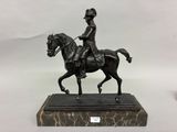 statue en bronze représentant un homme à cheval, posée sur un socle en marbre