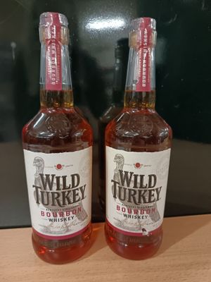 deux bouteilles de bourbon Wild Turkey posées sur une table en bois
