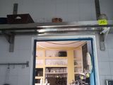 a door that is open in a kitchen with a shelf above it