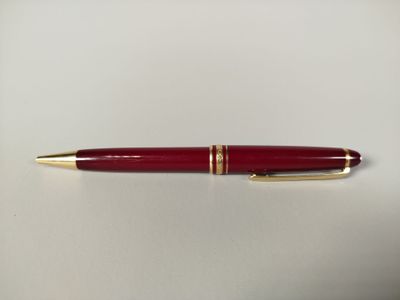 une image représentant un stylo rouge posé sur une table blanche
