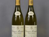 two bottles of wine sitting on top of a table next to each other