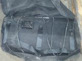 un sac noir posé par terre à côté d'un banc en bois