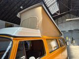 an orange van with a tent on top of it