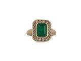 a close up of a ring with a green stone surrounded by diamonds