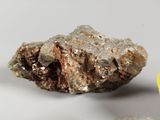 a rock with a piece of gold on it next to a coin