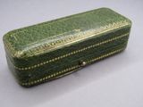 a small green box with gold trimmings on it