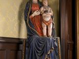 une statue représentant une femme tenant un bébé dans ses bras, posée sur un socle