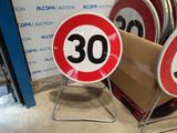 two red and white speed limit signs on a stand