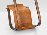 a wooden chair with a magazine holder attached to it