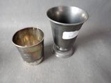 a silver cup and a silver cup sitting on a table