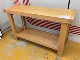 a wooden table with a shelf on it in a room