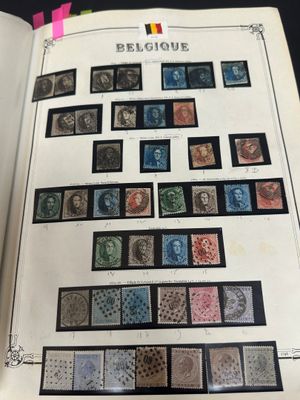 an open book with a bunch of stamps on it sitting on top of a table