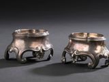 paire de bougeoirs en métal argenté avec des pieds en forme d'éléphant et des pieds