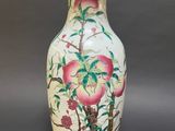 a vase with a painting on it sitting on a table