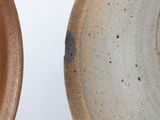 two brown and white plates sitting next to each other