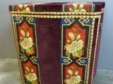 un sac violet orné de fleurs, posé par terre