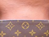 a close up view of a person ' s back with a louis vuitton bag
