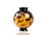 a vase with a design on it sitting on a white surface