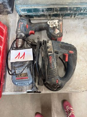 une perceuse filaire et un marteau perforateur filaire posés par terre