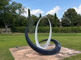 a sculpture in the middle of a grassy field