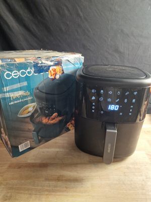 une boîte de nourriture posée sur une table à côté d'une friteuse à air chaud