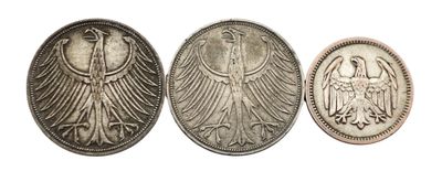 trois pièces d'argent représentant des têtes d'aigle sur fond blanc