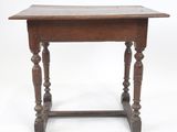 une vieille table en bois avec des pieds tournés et un plateau en bois