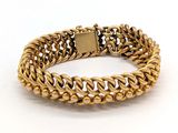 gros plan d'un bracelet en or sur fond blanc
