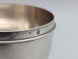 a silver bowl on a silver pedestal on a table