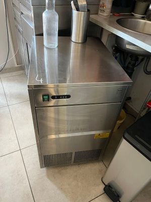 a bottle of water sitting on top of a stainless steel refrigerator